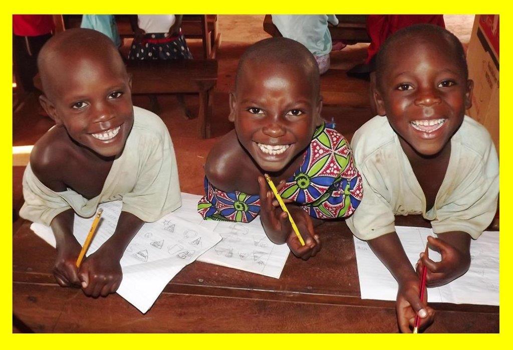 girls smiling at desks yellow